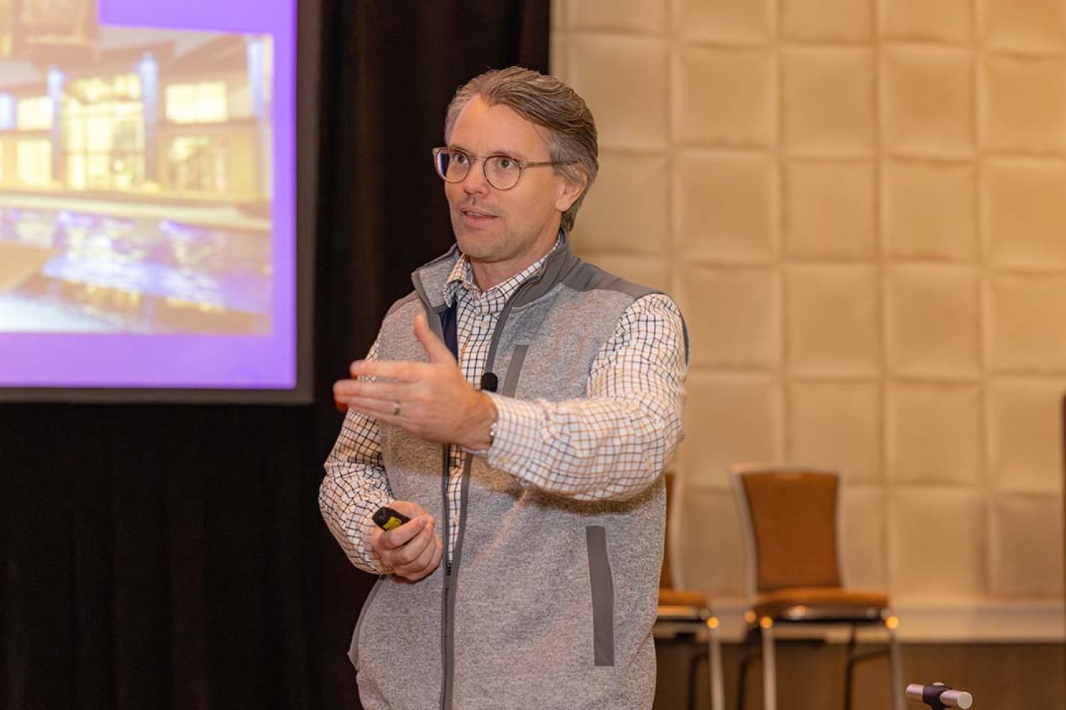 Ron Callis in a long sleeve shirt with a grey vest presenting