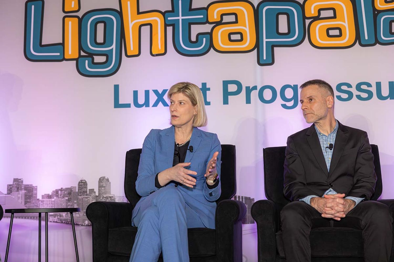 A woman in a blue suit speaks as a part of an expert panel at Lightapalooza